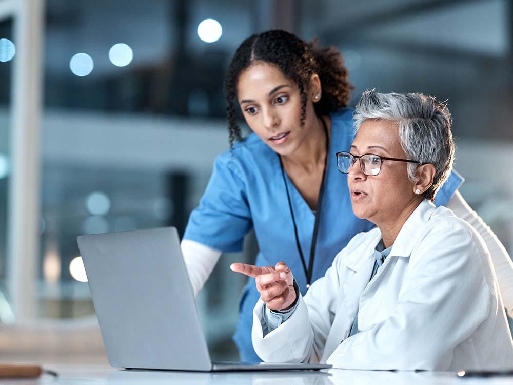 nurse and doctor looking at lap top